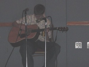 John singing and strumming his cute little ass off